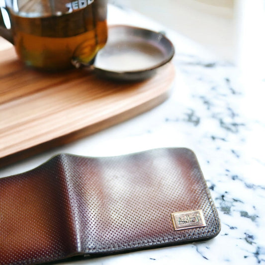 The handmade Brotachi Shade leather wallet exudes craftsmanship and style. Meticulously crafted from premium leather, its sleek design offers both durability and a touch of sophistication. With multiple card slots and a spacious bill compartment, it seamlessly combines functionality and elegance, making it an ideal accessory for the discerning individual.
